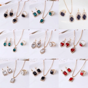 Dettaglio del set di gioielli con forme a goccia e cuore con strass colorati placcati oro