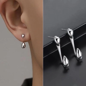 Detail view of silver liquid drop earrings with split design on ear and black background