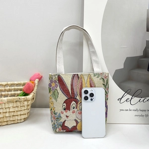 Ethnic embroidery handbag featuring a cartoon rabbit and floral tapestry on a canvas base