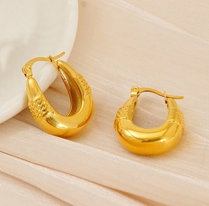 Detailed close-up of gold plated stainless steel U-shaped earrings with woven texture
