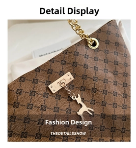 Detail of dark brown tote with gold chain strap and deer charm on patterned leather