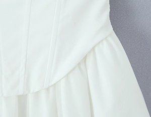 Detailansicht des weißen Korsettkleides mit Mesh-Patchwork und feiner Verarbeitungsqualität