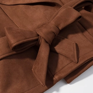Detail of the brown faux suede jacket featuring a knotted bow belt and fine stitching