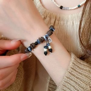 Detailed close-up of handmade acrylic coffee bean beaded bracelet with Fu character tag
