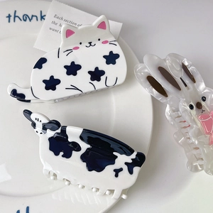 Close-up of animal shaped hair claws in cat, cow, and rabbit designs on a white plate