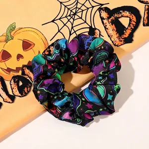 Detail of Halloween hair scrunchie with colorful skull and star patterns on black fabric