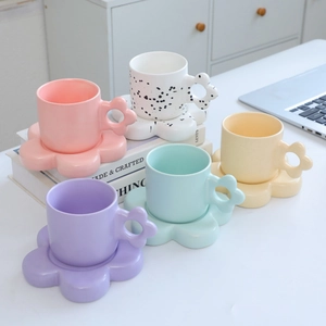Detail of flower-shaped ceramic coffee mug sets in five pastel colors on a clean background
