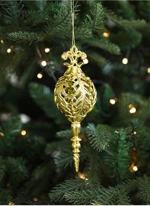 Detailed view of a golden vintage Christmas tree ornament hanging with warm bokeh lights