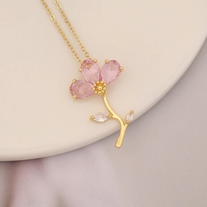 Close-up of pink gemstone flower pendant on 18k gold plated chain necklace