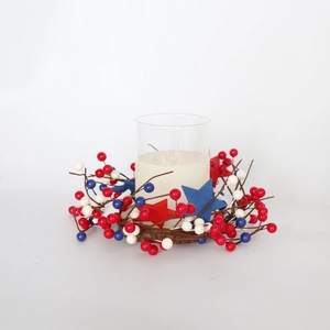 Patriotic July 4th candle ring with red white blue berries and wooden stars on white background