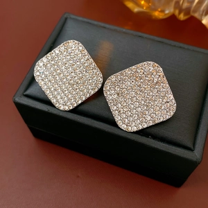 Macro shot of silver square cushion stud earrings with sparkling pavé diamonds
