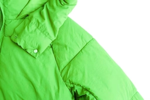 Detail der hellgrünen Steppjacke mit Druckknöpfen und wasserabweisendem Material
