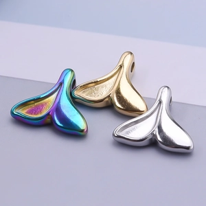 Macro shot of 304 stainless steel fishtail charms in rainbow, gold, and silver finishes