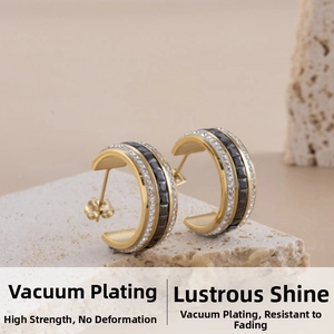 Detail of C-shaped gold-plated earrings with black square stones and white zircons