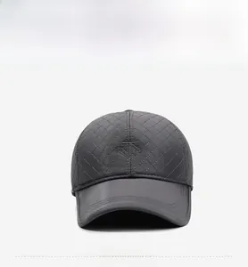 Detail of dark grey quilted baseball cap featuring embroidered logo and matte leather brim