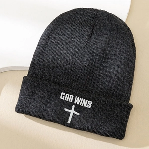 Close-up of God Wins white cross embroidery on dark grey knitted beanie hat