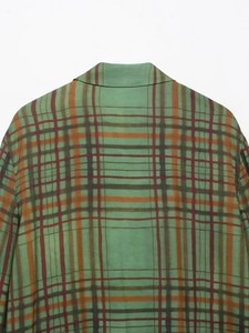 Détail du motif à carreaux vert et marron sur le col arrière et l'épaule du blazer