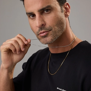 Detail of 18K gold and silver stainless steel snake chains on a male model neck