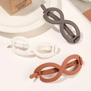 Three-piece set of large matte infinity-shaped hair claws in taupe, cream, and brick red
