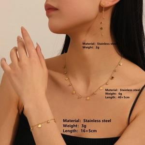 Elegant gold stainless steel jewelry set featuring necklace, bracelet, and earrings on model