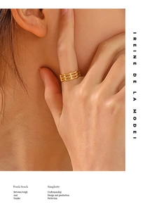 Close-up of a three-layer hollow geometric gold ring on model's finger with stylish design