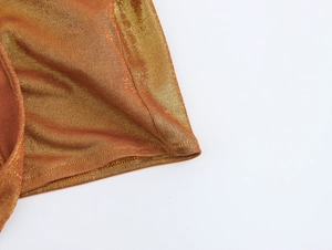 Vue macro détaillée de la texture du tissu doré brillant sur une robe de soirée sexy