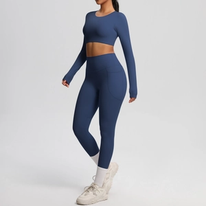 Detail of high-waist yoga leggings with side pockets and long sleeve navy crop top