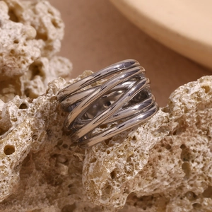Detailed view of silver multi-layer intertwined braided ring on natural stone background