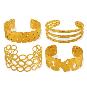 Set of four 18k gold plated open bangles featuring textured, bamboo, and geometric designs