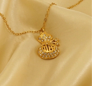 Vista macro di una collana a sacchetto d'oro con strass e carattere Fu sulla seta