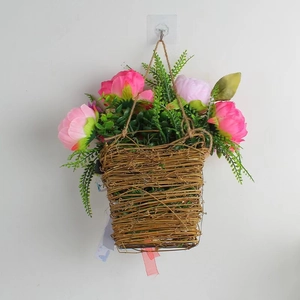 Detail of hanging wicker basket with pink peonies and green foliage for home decoration