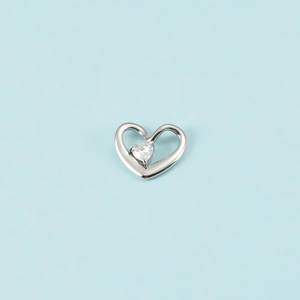 Gros plan d'un pendentif coeur en argent avec un cristal de pierre de naissance clair