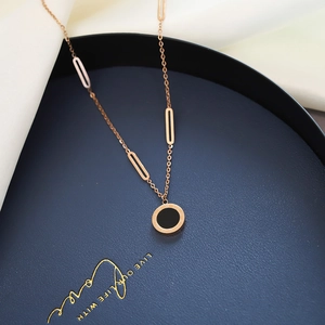 Close-up of rose gold necklace with Roman numerals pendant on a deep blue jewelry tray