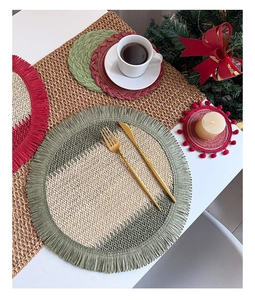 Close-up of woven paper rope placemats with festive red and green patterns and fringe