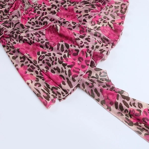 Dettaglio macro del tessuto in chiffon leopardato rosa con design a balze a strati