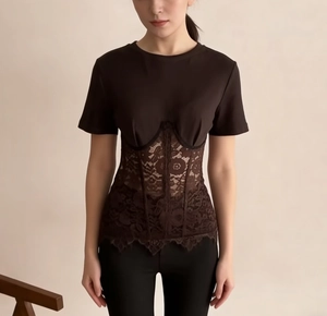 Detail of black T-shirt featuring intricate brown lace patchwork at the waistline