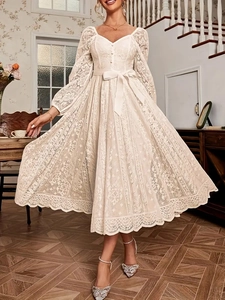 Détails de la robe en dentelle blanche avec boutons col V et ruban à la taille