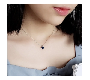 Detailed view of a model wearing a S925 sterling silver necklace with a blue agate pendant