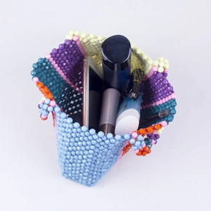 Sac à main coloré perlé fait main montrant sa capacité avec téléphone et maquillage