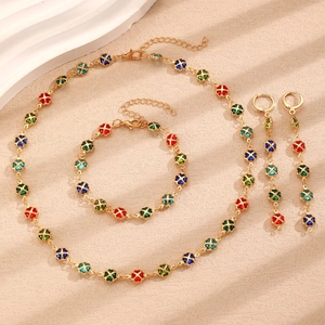 Detail view of colorful four-leaf clover jewelry set with gold necklace and earrings