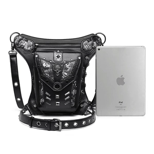 Multi-pocket punk waist bag with silver skull motif and chain detail next to an iPad