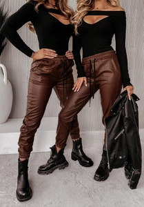 Dettaglio dei pantaloni jogger in ecopelle marrone con polsini elastici e outfit da moto
