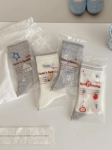Set of four cute cotton socks with star and heart patterns in individual packaging