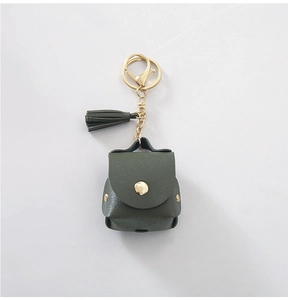 Detail of olive green PU leather AirPods case with gold metal ring and tassel
