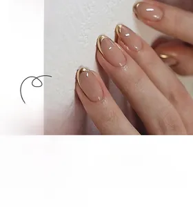 Detail of almond-shaped nude pink press on nails with gold metallic edging and hand display