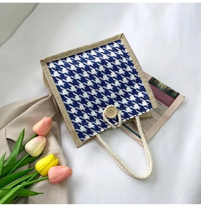 Detailed close-up of blue houndstooth canvas tote bag with wooden button and woven handles