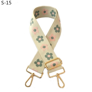 Close-up of retro floral embroidery on adjustable shoulder strap with gold hardware