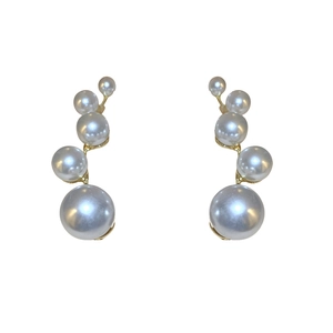 Elegant gradient size white pearl earrings with curved gold metal setting on white background