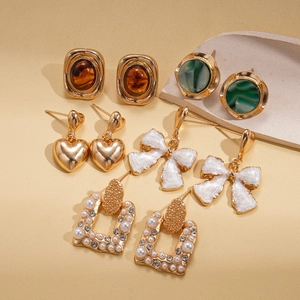 Elegant ten-piece retro gold earring set with pearls, resin hearts, and crystal bows