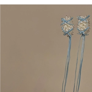 Détail de pinces à cheveux à nœud bleu ciel faites main avec perles blanches et pompons